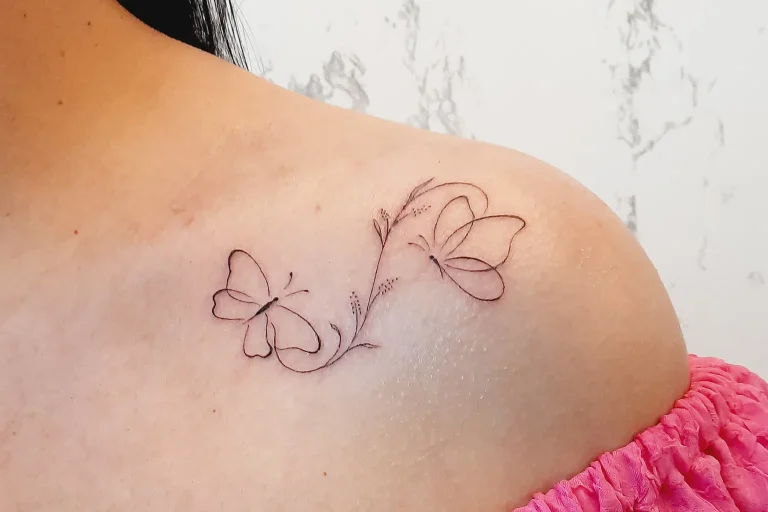 Tatuaje minimalista de mariposas en línea fina realizado en estudio de tatuajes para mujeres en Guadalajara